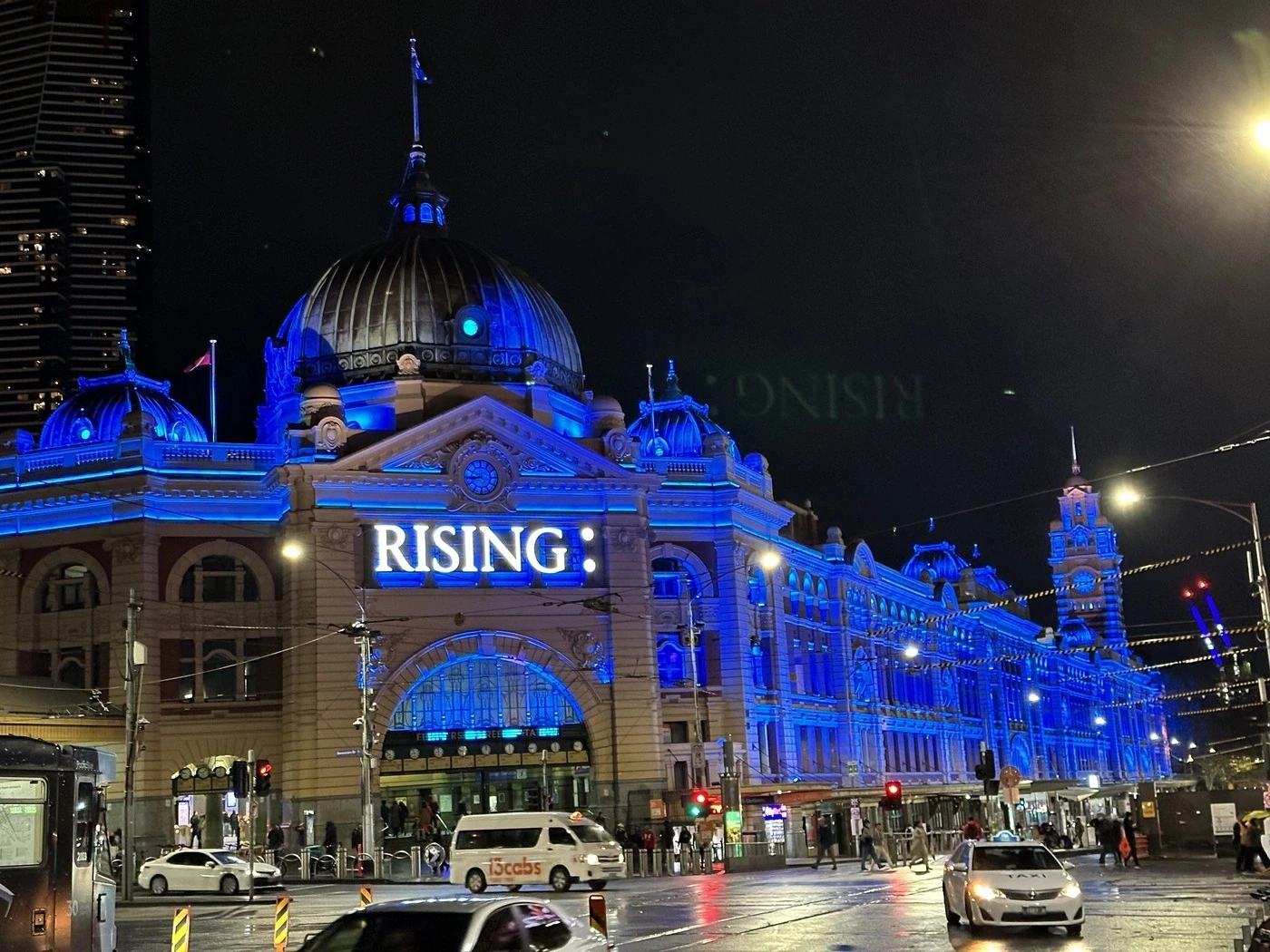 Flinders St lit up at night for Rising